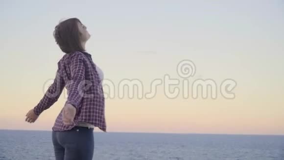 年轻女子站在山顶望着大海日落希腊克里特岛视频的预览图