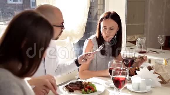 一家年轻的公司在餐馆用餐喝葡萄酒谈论一切餐厅里的食物视频的预览图