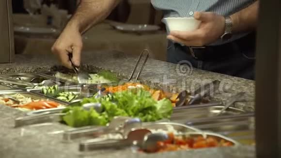 美食广场一个男人把蔬菜沙拉放在杯子里视频的预览图