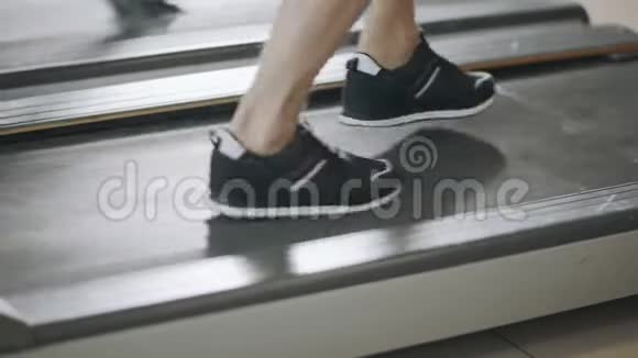健身馆里的跑步机上的特写脚视频的预览图
