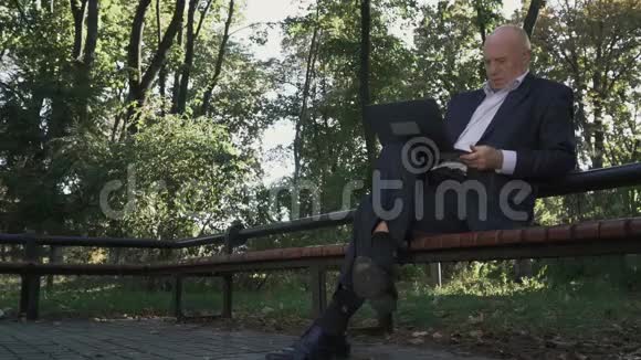 老人正在公园里写上网本视频的预览图
