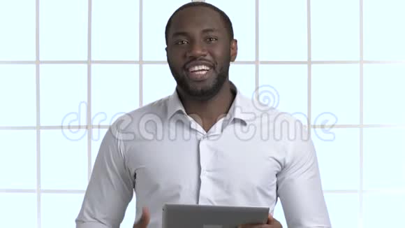 英俊的非洲黑人拿着平板电脑说话的肖像视频的预览图