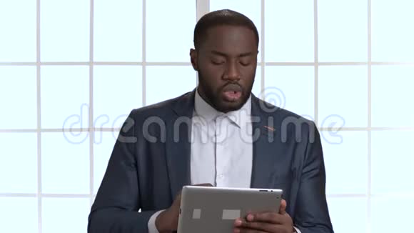 非洲黑人商人西装革履手持平板电脑视频的预览图