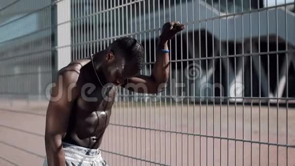 美国黑人男运动员在跑步锻炼后用瓶子泼水喝水脸部降温视频的预览图