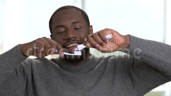 非裔美国人把牙膏挤在牙刷上视频的预览图