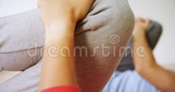 男子和女子在健身室做腿部伸展运动视频的预览图