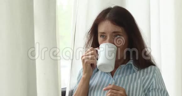 成熟的女人带着咖啡杯视频的预览图