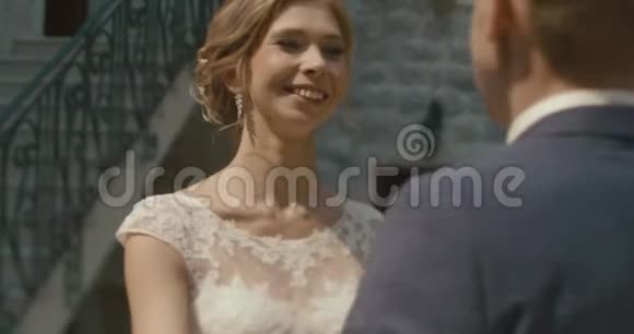 在黑山举行婚礼传统的欧洲仪式早在招待会之前4k新郎拥抱温柔可爱的金发女郎视频的预览图