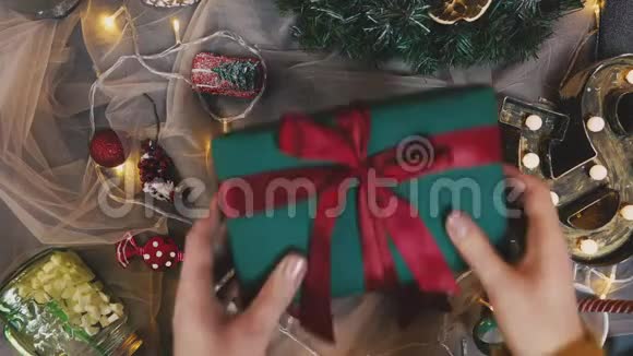 圣诞礼物赠送有些人手拿红色针织毛衣在红色盒子上做蝴蝶结带礼物横幅带复印空间视频的预览图