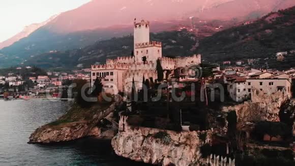 LagoGarda湖马尔切辛村的风景意大利岩石上的老城堡空中视频日落视频的预览图