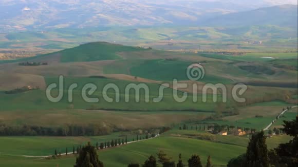 蜿蜒的道路穿过锡耶纳地区绿色的托斯卡尼山视频的预览图