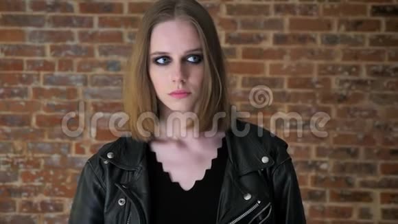 年轻疏离的女孩烟雾般的眼睛在镜头前看着悲伤砖背景视频的预览图