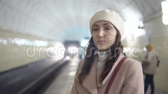 一个穿着梅托普利丁外套的漂亮女人在等火车视频的预览图