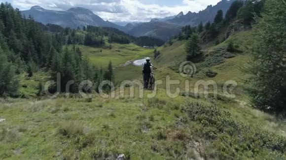 空中前进的山丘和森林树林与山地自行车女子观看景观全景与MTB电子自行车在视频的预览图