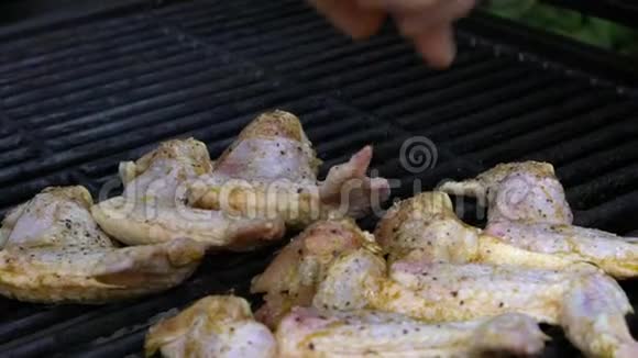 手把生的腌制鸡块放在烧烤架上烧烤烧烤视频的预览图