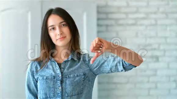 美丽的年轻女子竖起大拇指表示不喜欢视频的预览图