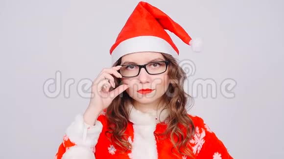 穿着圣诞老人衣服和眼镜的漂亮女人视频的预览图