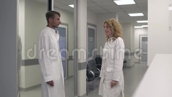 两位医生在医疗中心的走廊里交流视频的预览图