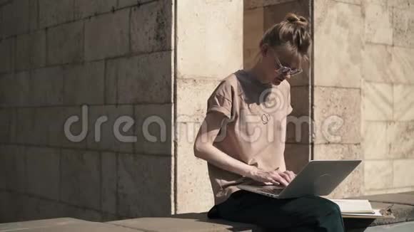 夏天漂亮的女孩在外面拿着笔记本电脑和书学习视频的预览图