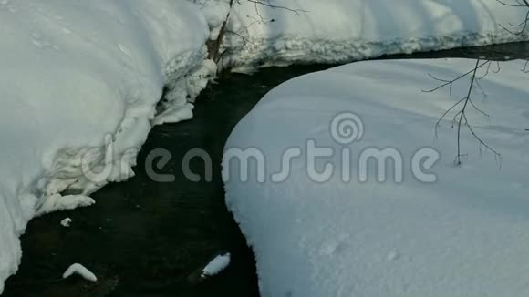 无冰的溪流春天的融水流过雪岸视频的预览图