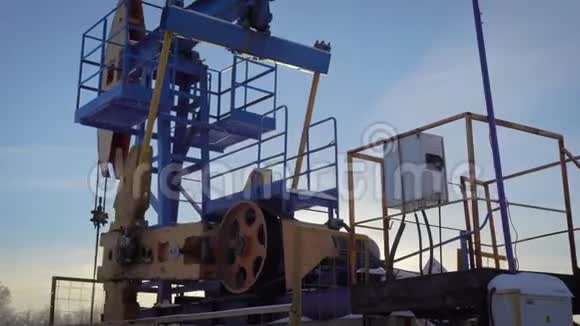 白天在冬季森林的油井上抽水机北部国家的石油开采视频的预览图