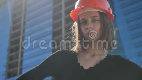 夏天的白天年轻强壮的女建筑工人手叉腰站着转头建筑视频的预览图