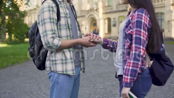 年轻人温柔地抚摸女友的手学生的爱关系视频的预览图