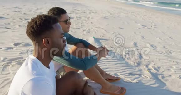 两个年轻的成年男性朋友在沙滩上放松4k视频的预览图