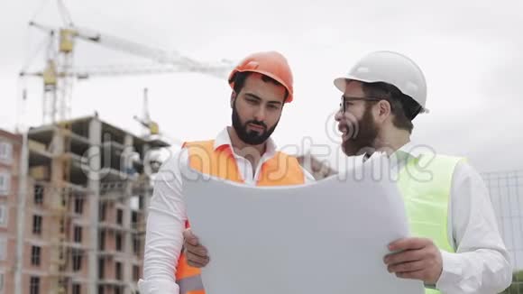 高层建筑施工现场或建筑工地男建筑工程师与建筑师讨论他们视频的预览图