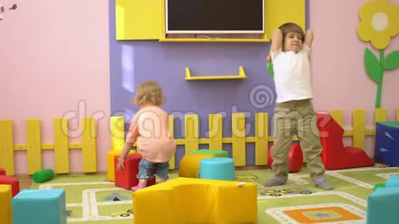 快乐的孩子在室内操场上玩柔软的多色积木学前教育视频的预览图