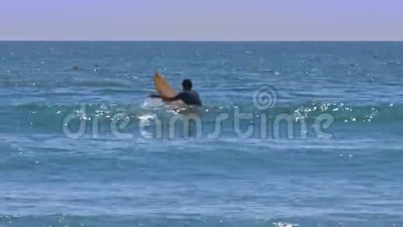 冲浪新手坐在船上在波浪之间划桨视频的预览图