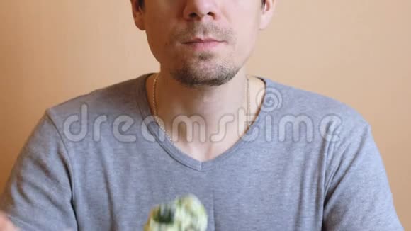 一个穿灰色t恤面目全非的人吃蔬菜沙拉手和嘴都贴了上去视频的预览图