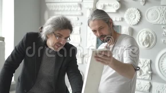 两位成熟的男性室内设计师正在讨论白色石膏视频的预览图