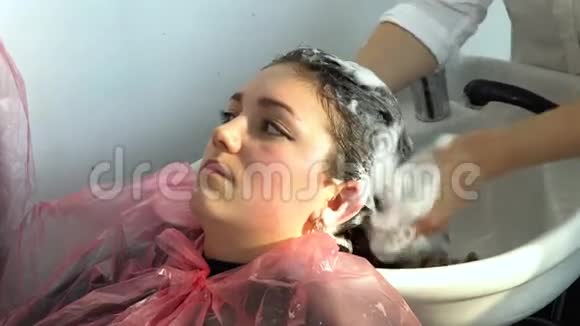 美容院理发店女孩在理发店洗头女孩放松了视频的预览图