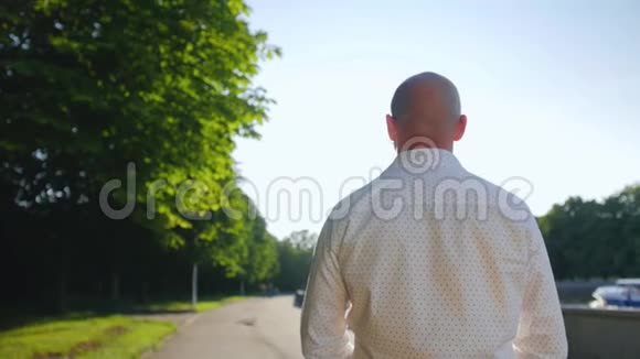 秃头男子站在公园的后视图和向前看近距离射击视频的预览图