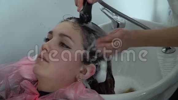 美容院理发店女孩在理发店洗头女孩放松了视频的预览图