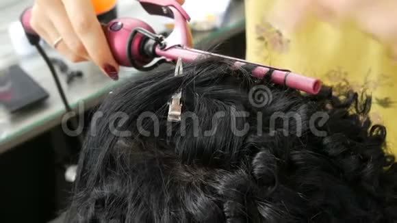 美发师造型师用特制的卷发器做一个特殊的卷发小卷发视频的预览图