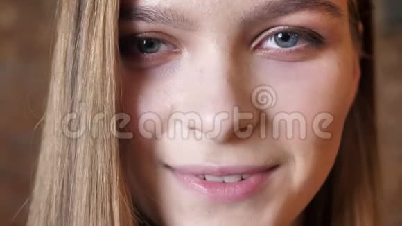 年轻女孩的脸在微笑看着镜头梦想的概念模糊的背景视频的预览图