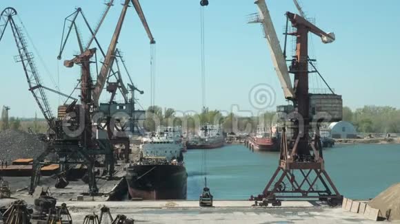 货运港船厂拖船和起重机的景观起重机在货船上装载建筑材料视频的预览图