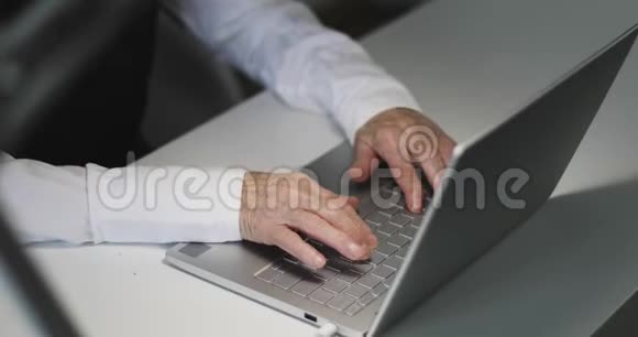 一个在键盘上打字的老商人的双手皱了起来视频的预览图