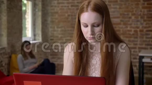 年轻的姜女商人在办公室里用笔记本电脑工作工作观念看镜头交流观念视频的预览图