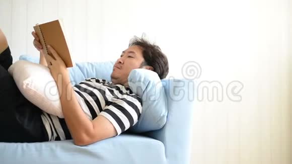 亚洲男人躺在沙发上看书视频的预览图