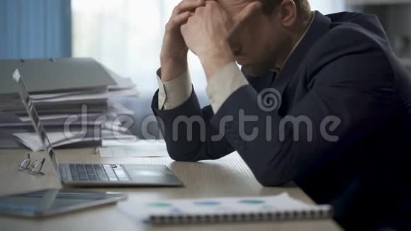 男性揉着头脸倒在桌子上劳累过度压力大视频的预览图