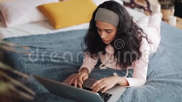 一个女人在她的电脑上收到信息后会非常生气和生气她躺在床上回家视频的预览图