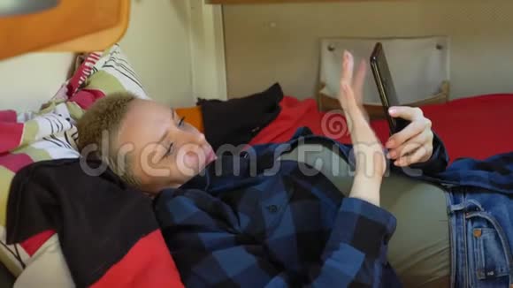 一个女人用手机躺在家里的床上视频的预览图