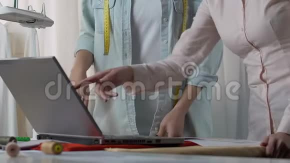 设计师和助理在笔记本电脑上看布展讨论窗帘视频的预览图