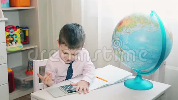 小男孩用计算器计算他的积蓄视频的预览图