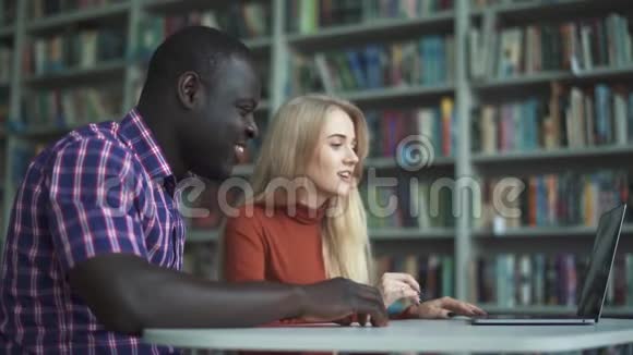 欧洲女人和非洲裔美国男人用笔记本电脑和朋友聊天视频的预览图
