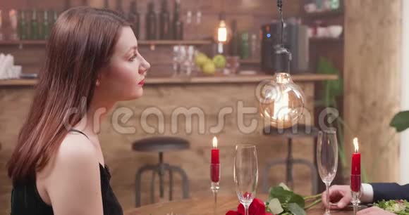 年轻女孩在浪漫的晚餐中和她的约会对象交谈视频的预览图