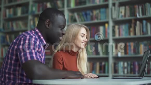 欧洲女人和非洲裔美国男人用笔记本电脑和朋友聊天视频的预览图